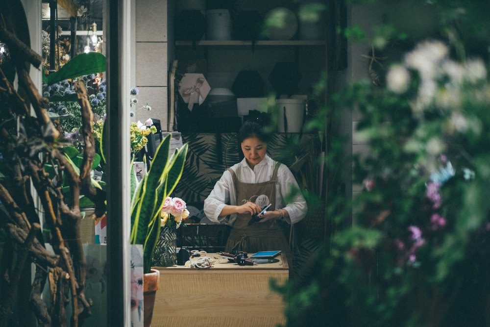 A shop owner standing beside a table in her store